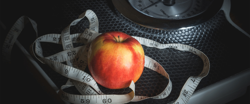 Waage, Maßband und Apfel